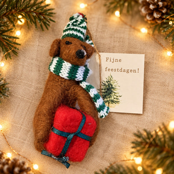 Kersthanger hondje met cadeautje en groene sjaal met kaartje Fijne feestdagen en kerstachtergrond