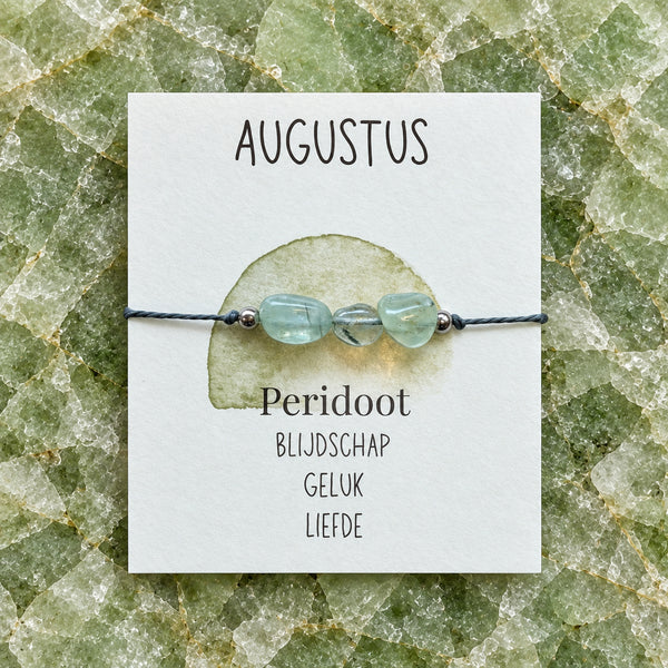 Maandarmband augustus op bijpassende edelsteenachtergrond