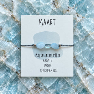 Maandarmband maart op bijpassende edelsteenachtergrond
