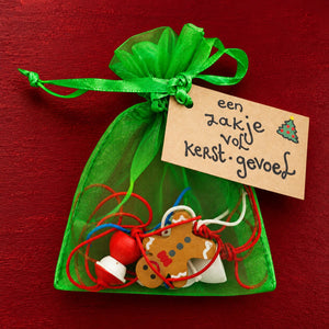 Zakje vol kerst gevoel plat op gekleurde achtergrond
