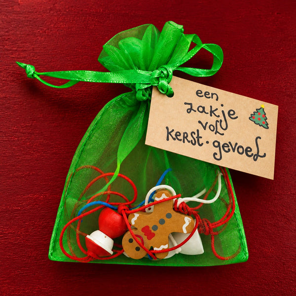 Zakje vol kerst gevoel plat op gekleurde achtergrond